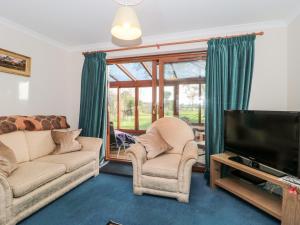 a living room with two couches and a flat screen tv at Morgan House in Bridgwater