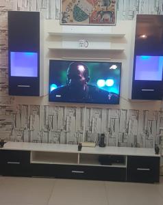 uma televisão numa parede com dois monitores em Appartement meublé liberté 6 em Dakar