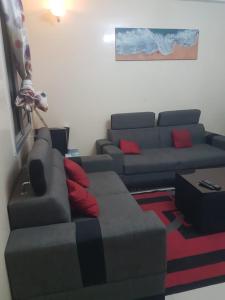 uma sala de estar com um sofá e uma sala de estar em Appartement meublé liberté 6 em Dakar