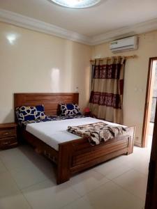 um quarto com uma grande cama de madeira num quarto em Appartement meublé liberté 6 em Dakar