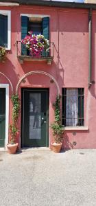 a pink building with two windows and a door with flowers at Elegante alloggio in casa storica-Borgo Portello in Padova