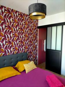 um quarto com uma cama roxa e uma parede colorida em Maison du petit p(a)in em Cucq