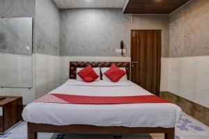 a bedroom with a large bed with red pillows at OYO Flagship Hotel Sapna Residency in Mumbai