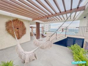 a porch with two swinging hammocks on a house at Arenka - 2BR w Private Pool & Sunset Rooftop in Bucerías