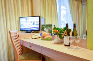 a desk with a television and wine bottles and glasses at Hotel Gergana in Albena