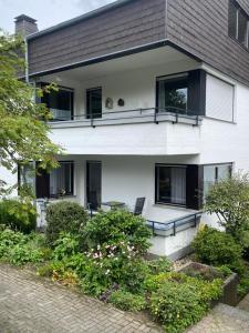 een wit huis met zwarte ramen en een patio bij Ferienwohnung Gierse in Schmallenberg