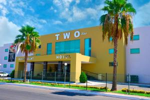 un hôtel avec des palmiers devant lui dans l'établissement Hotel Two Select, à Culiacán