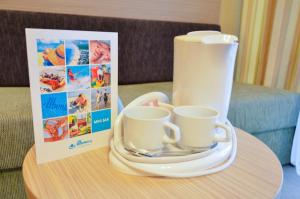 a coffee maker and two cups on a table at Hotel Gergana - Ultra All Inclusive in Albena