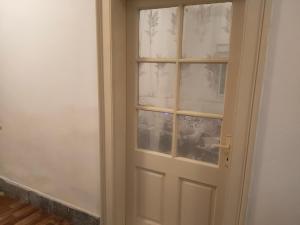 una puerta con una ventana de cristal en una habitación en Warm and comfortable apartment, en Subotica