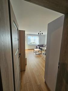 a hallway with a door and a living room at Nowa piaskowa apartament in Wągrowiec