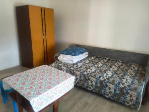 a bedroom with a bed and a table and a cabinet at Warm and comfortable apartment in Subotica