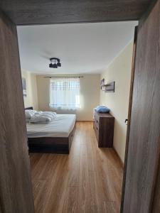 a bedroom with a bed and a wooden floor at Nowa piaskowa apartament in Wągrowiec