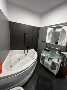 Un baño con una bañera grande y un lavabo. en Infinity Villa, en Buşteni 43 fotos más