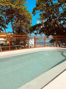 una piscina vacía con árboles en el fondo en AL MAR SUÍTES en Praia do Forte