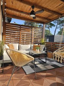 a patio with a couch and a ceiling fan at Bajki Mobile home in Biograd na Moru