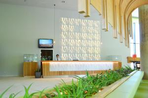 a lobby with a reception desk with plants in the foreground at Hotel Gergana - Ultra All Inclusive in Albena
