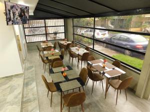 un restaurante con mesas y sillas y vistas a un coche en HOTEL MX BOGOTA, en Bogotá