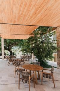 een groep tafels en stoelen onder een houten paraplu bij PiedraViva Tepoztlán in Tepoztlán