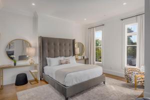 a bedroom with a bed and a chair and windows at The George - Luxury Boutique Inn in Napa