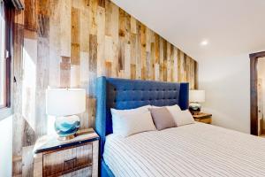 a bed with a blue headboard in a bedroom at Ski-In, Ski-Out Designer Condo in Truckee +28 photos