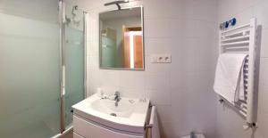 a white bathroom with a sink and a mirror at Corazón de Javalambre 