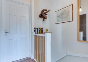 een kamer met een witte deur en een plank met boeken bij Herbert's Place in Swanage