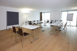 a class room with tables and chairs and a chalkboard at Hotel AVA in Sempach Station