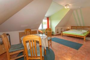 Zimmer im Dachgeschoss mit einem Bett, einem Tisch und Stühlen in der Unterkunft Ferienwohnung Locke in Kluis