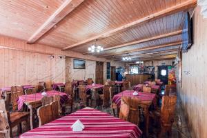 restauracja ze stołami i krzesłami w pokoju w obiekcie ПІД МАГУРОЮ w mieście Pilipets