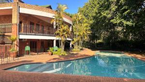 a swimming pool in front of a house at White River Selfcatering at Greenway woods House no 9 in White River