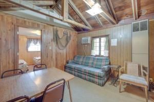 a living room with a couch and a table at Stone Lake Cabin with Private Deck and Fire Pit! in Northwoods Beach