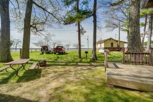 a yard with a picnic table and trees and a house at Stone Lake Cabin with Private Deck and Fire Pit! in Northwoods Beach