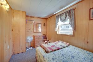 a bedroom with a bed and a window at Stone Lake Cabin with Private Deck and Fire Pit! in Northwoods Beach