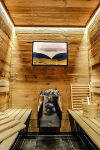 a sauna with a tv on a wooden wall at Leitenhof Fam.Steger in Uttendorf