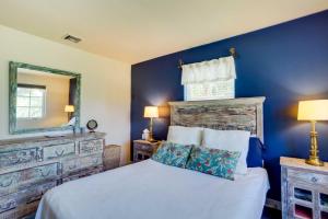 Dormitorio azul con cama y espejo en West Palm Beach Home with Fenced-In Yard and Deck! en West Palm Beach