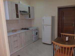 a kitchen with white cabinets and a refrigerator and a table at Lunis in Geghanist