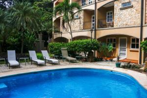 Una gran piscina azul frente a un edificio en Villa Verde I - 3, en Tamarindo