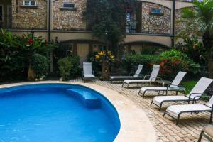 Una piscina con tumbonas y un edificio. en Villa Verde I - 3, en Tamarindo