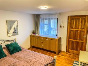 a bedroom with a bed with a dresser and a window at Little house in Kaunas