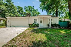 a large white house with a garage at Beautiful Pool House in Old Seminole Heights! in Tampa