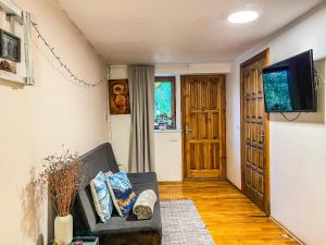 a living room with a couch and a flat screen tv at Little house in Kaunas