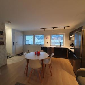 cocina con mesa y sillas en una habitación en Ramfjord Apartment, en Tromsø