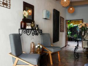 a living room with two chairs and a table at Hotel Boutique Casa Flor de Mayo in Mérida