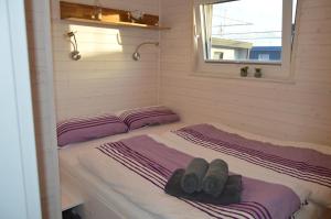 Dos camas en una habitación pequeña con toallas. en Hausboot Hecht en Egernsund