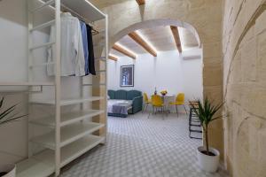 a living room with a staircase and a dining room at The Glen Residences in Senglea