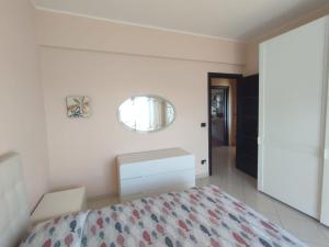 a bedroom with a bed and a mirror on the wall at B&B Dolce Risveglio in Boissano