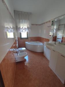 bagno con 2 lavandini, vasca e servizi igienici di B&B Dolce Risveglio a Boissano