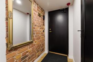 un couloir avec une porte noire et un mur de briques dans l'établissement Loft Black and Red, à Tallinn