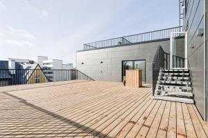 - une terrasse en bois avec un escalier dans un bâtiment dans l'établissement Loft Black and Red, à Tallinn