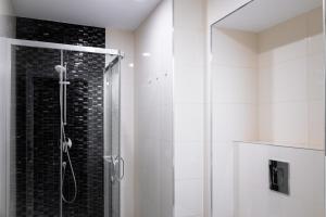 a shower with a glass door in a bathroom at Washington Apartment in Prague
